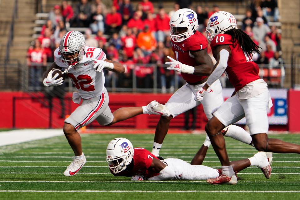 Ohio State's TreVeyon Henderson runs through the Rutgers defense on Saturday.