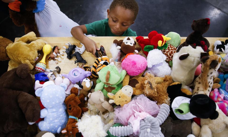 A four-year-old boy picks out a toy from a donations table at the convention in downtown Houston, which has sheltered about a third of the city’s displaced people.