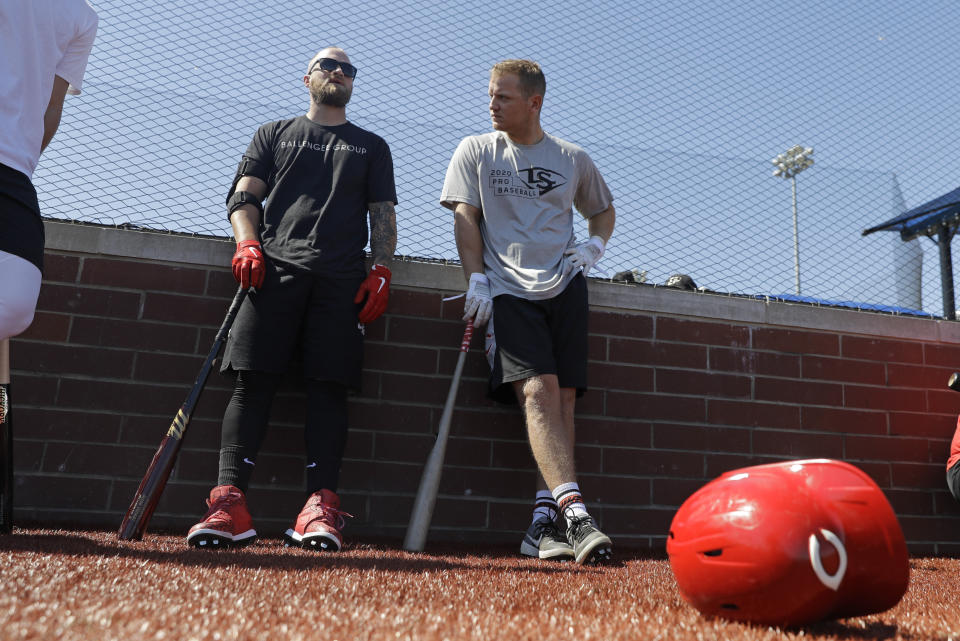 Cincinnati Reds' Tucker Barnhart, left, talks with Josh VanMeter during a workout at Grand Park, Friday, June 12, 2020, in Westfield, Ind. Proceeds from the event will go to Reviving Baseball in the Inner City of Indianapolis. (AP Photo/Darron Cummings)