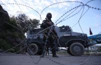 An Indian security personnel stands guard on a deserted road during restrictions after scrapping of the special constitutional status for Kashmir by the Indian government, in Srinagar