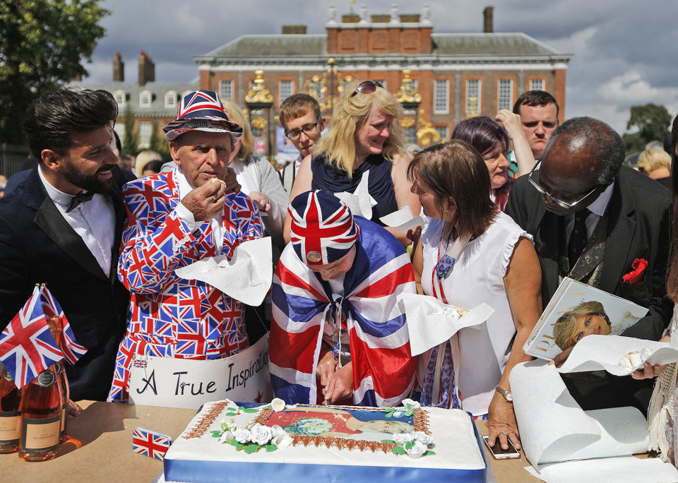 <p>Royal fans for the late Diana, Princess of Wales, cut a cake outside Kensington Palace in London, Aug. 31, 2017. (Photo: Frank Augstein/AP) </p>