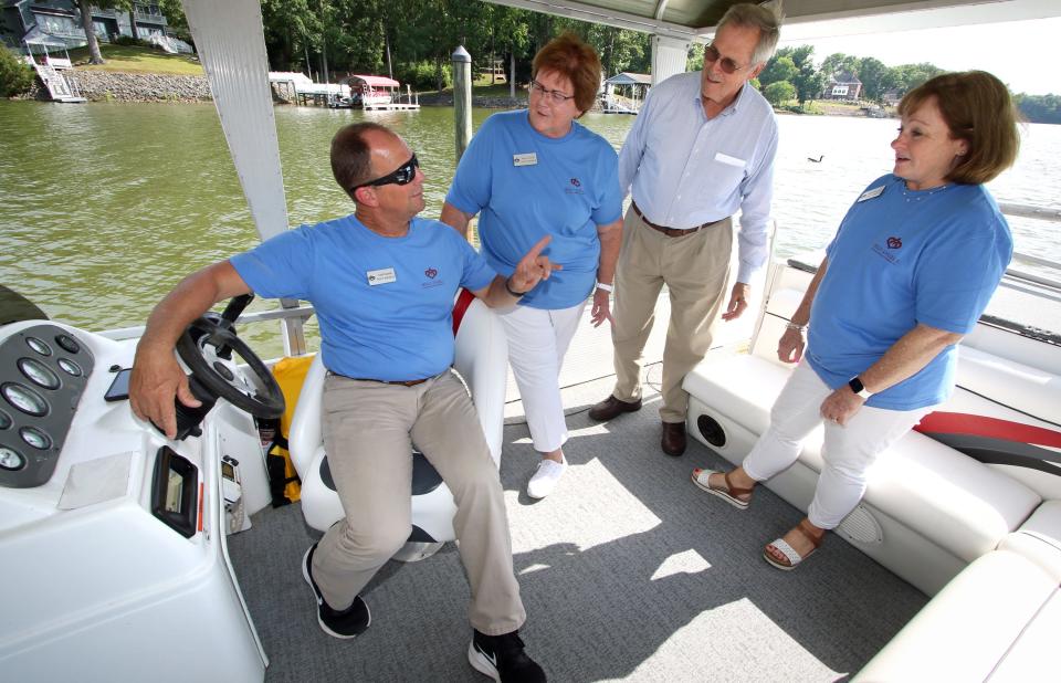 Todd Garrett, Regina Moody, chairman of the board Hans Lengers and Elena Benedict check out a pontoon boat Spirit of Maria during the Grand Reopening of Camp Hope Tuesday afternoon, July 12, 2022, on River Run near Belmont.