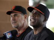 San Francisco Giants manager Bruce Bochy, left, listens as former player Barry Bonds speaks at a news conference before a spring training baseball game in Scottsdale, Ariz., Monday, March 10, 2014. Bonds starts a seven day coaching stint today. (AP Photo/Chris Carlson)