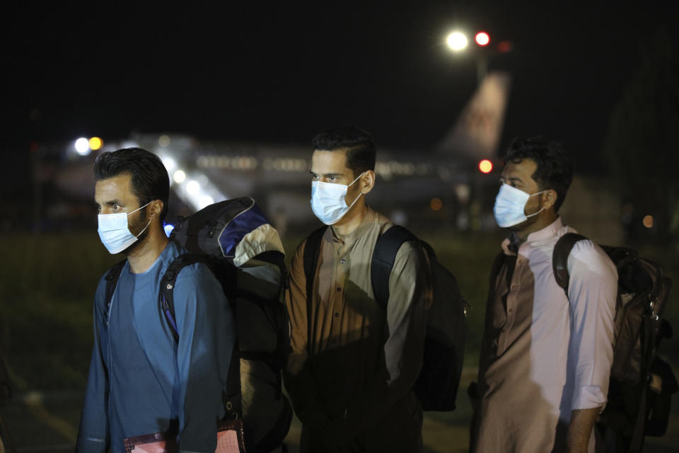 Evacuated citizens from Afghanistan arrive at Tirana International Airport in Tirana, Albania, Friday, Aug. 27, 2021. A government decision has planned that the Afghans may stay at least a year during which they will proceed with their application for special visas before they move on to the U.S. for final settlement. (AP Photo/Franc Zhurda)