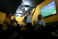 Fans celebrate after Ukraine's Andriy Yarmolenko scored the opening goal in a World Cup 2022 qualifying play-off soccer match between Ukraine and Scotland at a bar in Kyiv, Ukraine, Wednesday, June 1, 2022. (AP Photo/Natacha Pisarenko)