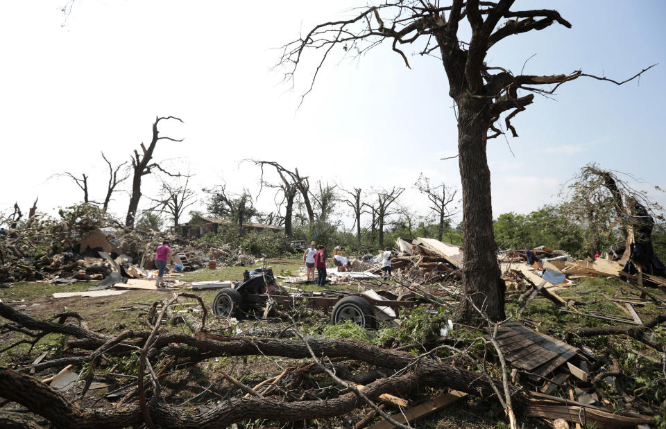 Vecinos ayudan a limpiar la ona de Sahwnee, Oklahoma, azorasa por un tornado el 20 de mayo de 2013.