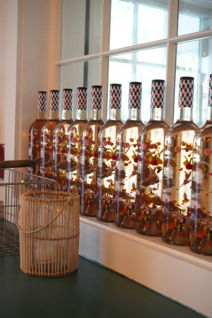 Christian's restaurant with a row of the specially designed bottles on a shelf. The bottles have a geographic print at the cap and neck, with a floral design on the body.