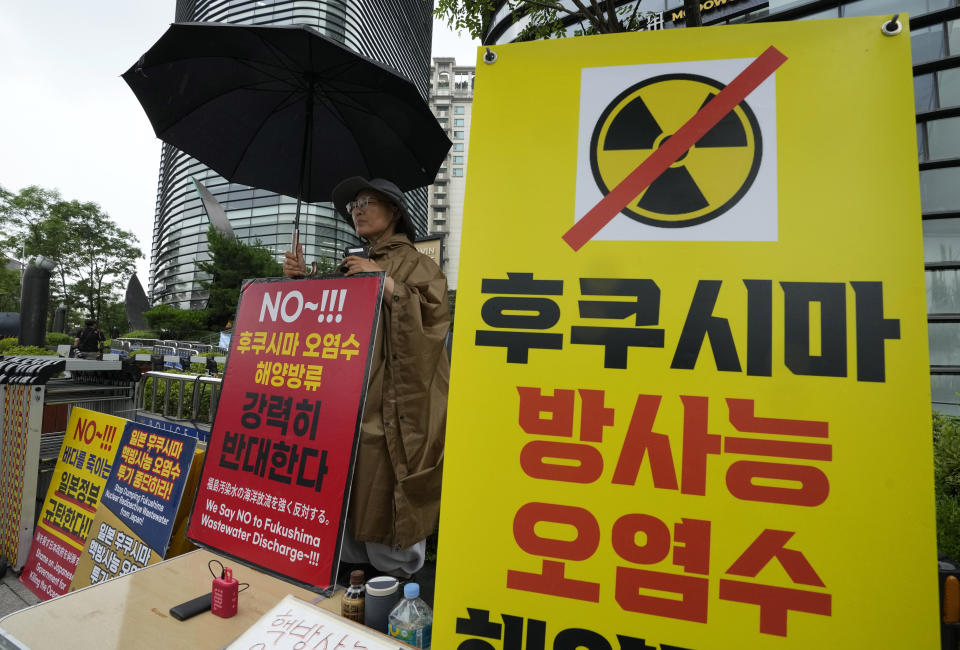 A Buddhist monk protests against the Japanese government's decision to release treated radioactive wastewater from the damaged Fukushima nuclear power plant, near a building which houses the Japanese Embassy in Seoul, South Korea, Tuesday, July 4, 2023. The head of the U.N. nuclear agency is in Japan to meet with government leaders Tuesday and to see final preparations for the release of treated radioactive wastewater into the sea from the damaged Fukushima nuclear plant, on a visit Japan hopes will give credibility to the contentious plan. The letters read, "The treated radioactive water from the Fukushima." (AP Photo/Ahn Young-joon)