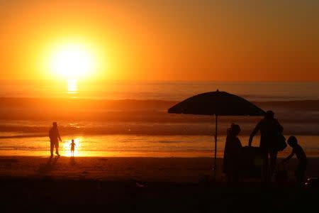 Families cool off at sunset in Solana Beach following a record setting day of temperatures according to local media, in Southern California, U.S., October 23, 2017. REUTERS/Mike Blake