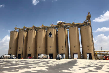 Trucks load sand from storage silos at Black Mountain Sand's mine and processing facility near Odessa, Texas, U.S., July 16, 2018. REUTERS/Liz Hampton