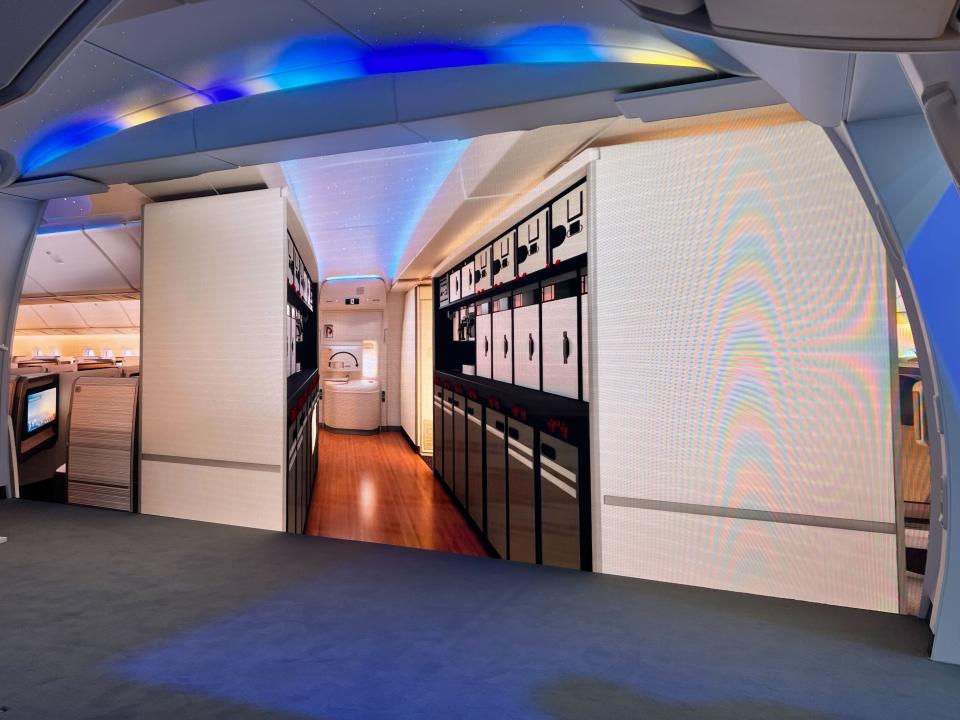 Interior mock display of Boeing 777X plane, showing an illustration of a plane's galley on a wall.
