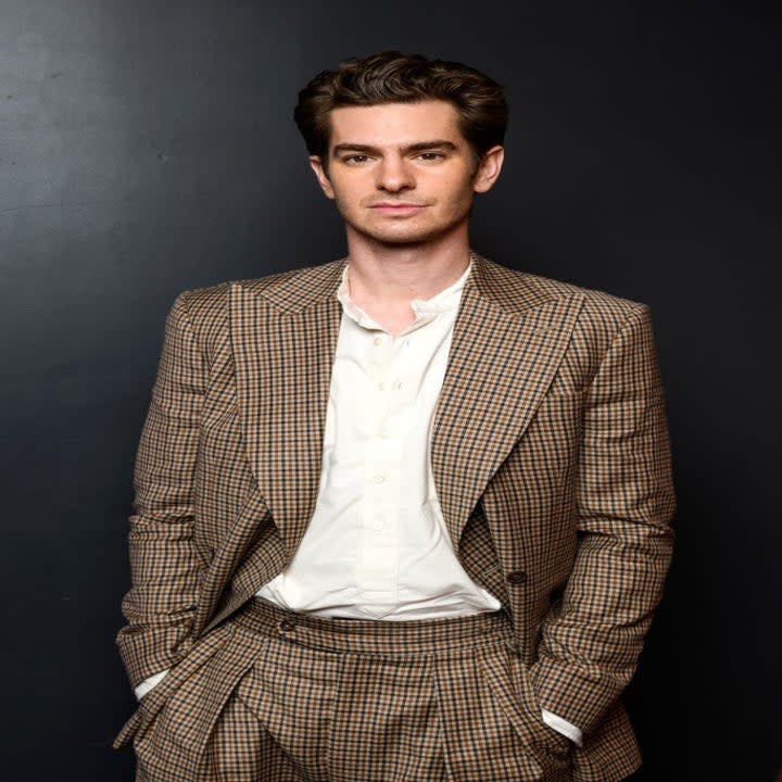 Shot of Andrew with his hands in the pockets of his checkered ensemble suit