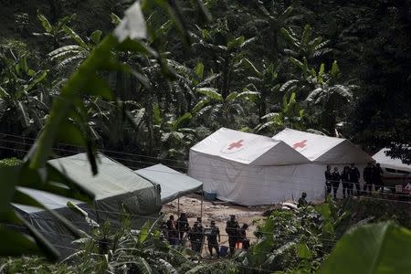 Soldiers and policemen (R) keep watch outside tents, being used as temporary morgue, at an area affected by a mudslide in Santa Catarina Pinula, on the outskirts of Guatemala City, October 5, 2015. REUTERS/Josue Decavele