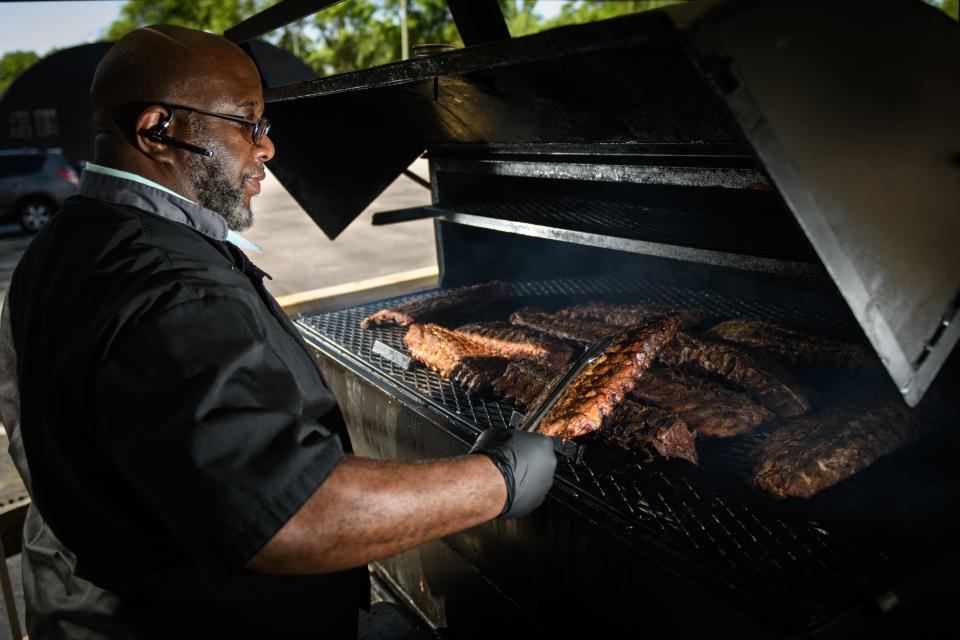 Chef Sheldon China smokes pork ribs outside his restaurant, Melvin's at Riverside at 1130 Person St.
