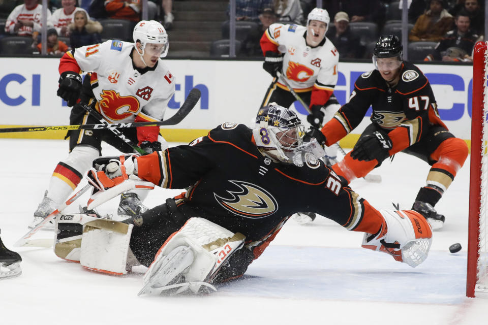 Calgary Flames center Mikael Backlund, left, scores past Anaheim Ducks goaltender John Gibson during the first period of an NHL hockey game in Anaheim, Calif., Thursday, Feb. 13, 2020. (AP Photo/Chris Carlson)