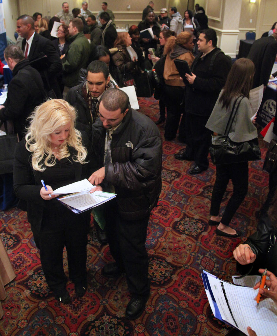 Eva Sikora, left, an administrator at the Real Estate Education Center, discusses job opportunities with attendees at JobEXPO's job fair on Wednesday, Jan. 25, 2012 in New York. The number of people seeking unemployment benefits rose last week, after falling to a nearly four-year low the previous week. (AP Photo/Bebeto Matthews)