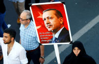 <p>A woman holds a portrait of Turkey’s President Tayyip Erdogan during a ceremony marking the first anniversary of the attempted coup at the Bosphorus Bridge in Istanbul, Turkey July 15, 2017. The words on the sign read: “We are here to be the slaves of the nation, not to be the master.” (Photo: Osman Orsal/Reuters) </p>