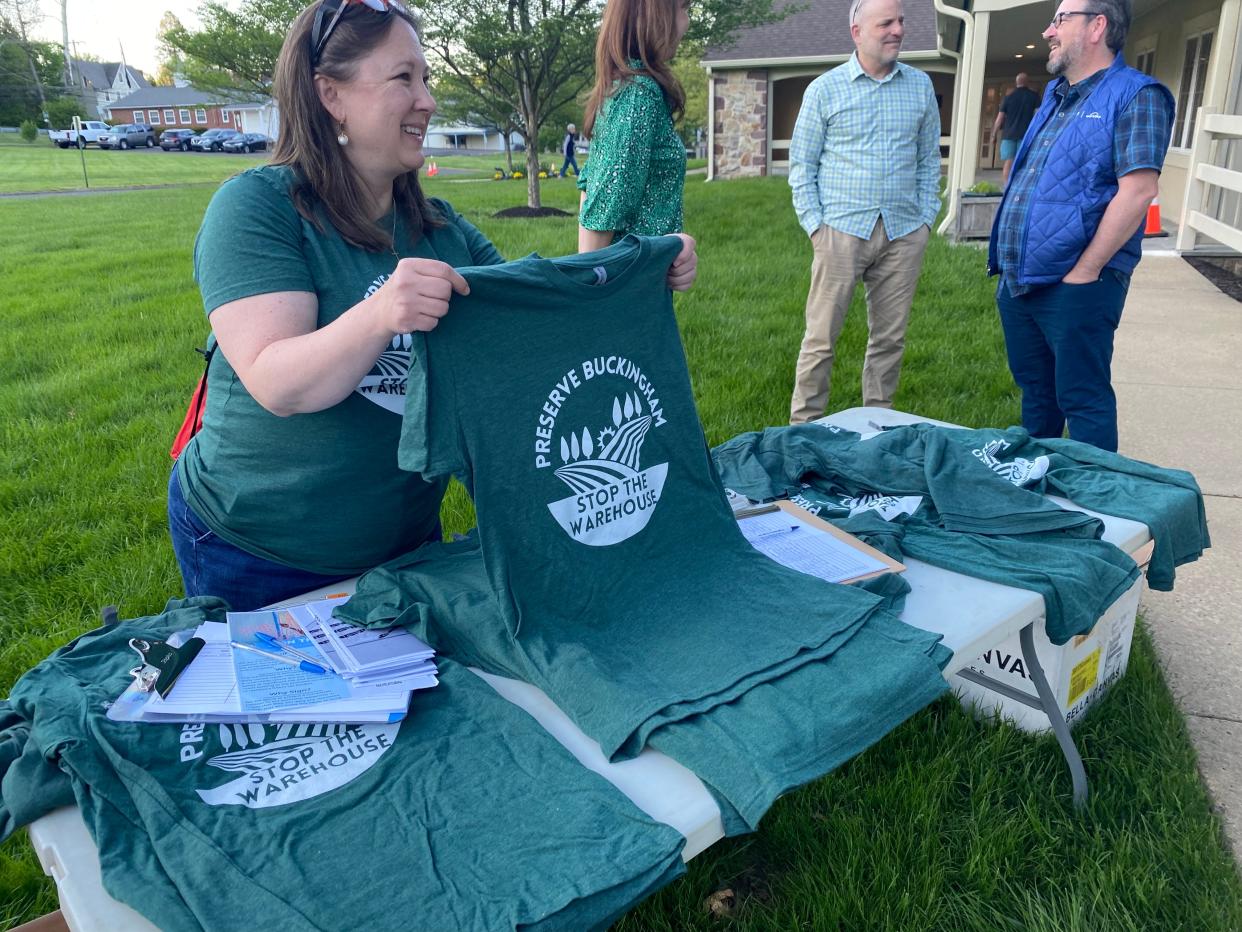 Jennifer Potthoff, a Buckingham resident and member of the Stop the Buckingham Warehouse coalition, distributes t-shirts before the start of a Buckingham Township planning commission meeting on Wednesday, May 1, 2024.