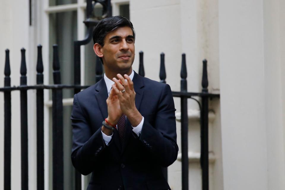 Britain's Chancellor of the Exchequer Rishi Sunak participates in a national "clap for carers" to show thanks for the work of Britain's NHS (National Health Service) workers and other frontline medical staff around the country as they battle with the novel coronavirus pandemic, in Downing Street in London on May 21, 2020. - The British government on on May 21 announced that foreign care workers would be exempt from a charge imposed on migrants to fund the health service, after an outcry sparked by the coronavirus outbreak. (Photo by Tolga AKMEN / AFP) (Photo by TOLGA AKMEN/AFP via Getty Images)