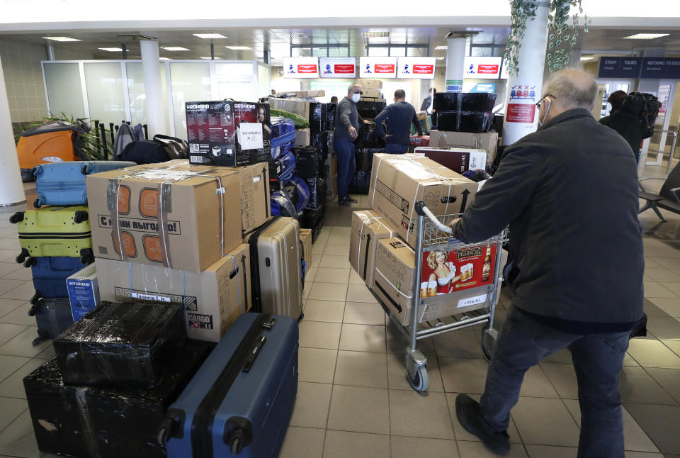 People check in luggages at the Vaclav Havel airport after a Russian special government plane landed in Prague, Czech Republic, Monday, April 19, 2021. Czech Republic is expelling 18 diplomats identified as spies over a 2014 ammunition depot explosion. On Saturday, April 17, 2021, Prime Minister Andrej Babis said the Czech spy agencies provided clear evidence about the involvement of Russian military agents in the massive explosion that killed two people. (AP Photo/Petr David Josek)