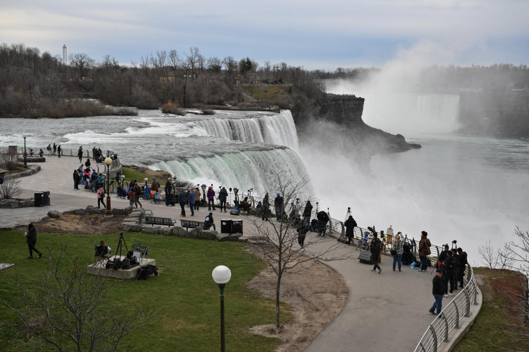From above, several dozen people along an observation deck at Niagara Falls State Park.