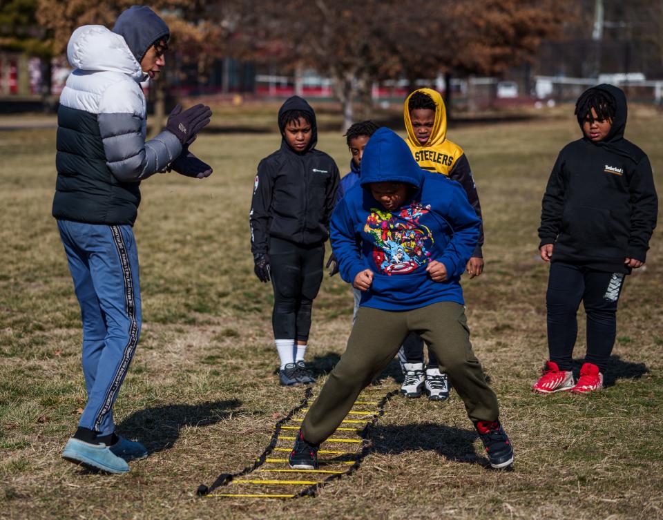 Indy Steelers coach Dontaye Hamilton cheers on young players during an agility drill Saturday, Feb. 4, 2023, during football conditioning practice at Tarkington Park in Indianapolis. The practice was the first since the death of the team's founder, Richard Donnell Hamilton, Dontaye's father, nearly four weeks prior.