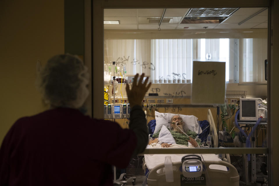 Nurse Susan Morales waves to David Feinour, a 71-year-old COVID-19 patient, at St. Jude Medical Center in Fullerton, Calif., Friday, July 10, 2020. "We still have emotions," said Morales who has been a nurse for 42 years. "The day you don't is the day you should get out of nursing. That's what I would tell my students." (AP Photo/Jae C. Hong)