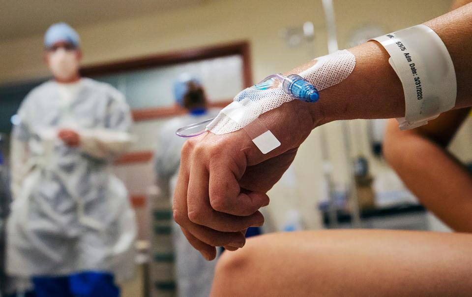 A patient with COVID-19 symptoms is prepared for admission by emergency room nurses at Gulf Coast Medical Center in Fort Myers, Fla.