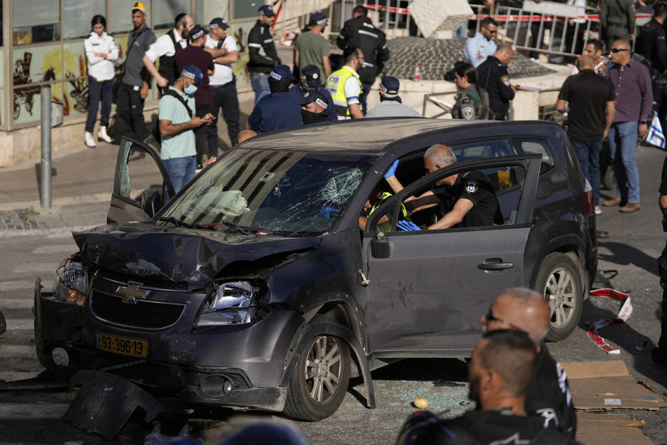 Israeli police examine the scene of a car ramming attack, in Jerusalem, Monday, April 24, 2023. Israeli Prime Minister Benjamin Netanyahu says multiple people have been attacked and wounded near a popular market in Jerusalem as Israel was set to mark its Memorial Day for fallen soldiers. Netanyahu spoke Monday moments after medics reported a suspected attack injured five people near the bustling, open-air Mahane Yehuda market. (AP Photo/Ohad Zwigenberg)