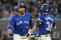 Toronto Blue Jays outfielder George Springer, left, celebrates with teammate Davis Schneider (36) after scoring against the Colorado Rockies during first-inning baseball game action in Toronto, Sunday, April 14, 2024. (Frank Gunn/The Canadian Press via AP)