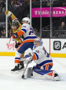 New York Islanders goaltender Ilya Sorokin (30) makes the save as defenseman Scott Mayfield (24) shields Vegas Golden Knights center Brett Howden from the net during the second period of an NHL hockey game, Sunday, Oct. 24, 2021, in Las Vegas. (AP Photo/Rick Scuteri)