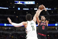 Chicago Bulls' Nikola Vucevic (9) looks to shoot over Milwaukee Bucks' Brook Lopez during the first half of an NBA basketball game Thursday, Feb. 16, 2023, in Chicago. (AP Photo/Charles Rex Arbogast)