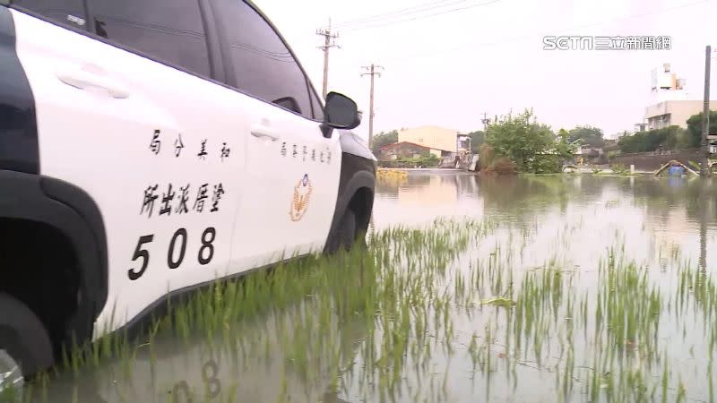 警車右前車頭意外卡進淹水的稻田中，動彈不得。