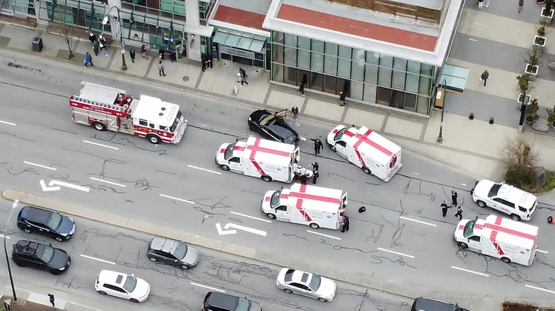 Ambulances and emergency personnel are seen on a road at Lynn Valley Plaza after a stabbing at a public library in a suburb in Vancouver