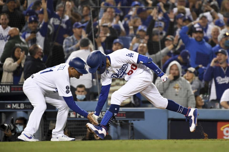 Dodgers' Mookie Betts celebrates with third base coach Dino Ebel.