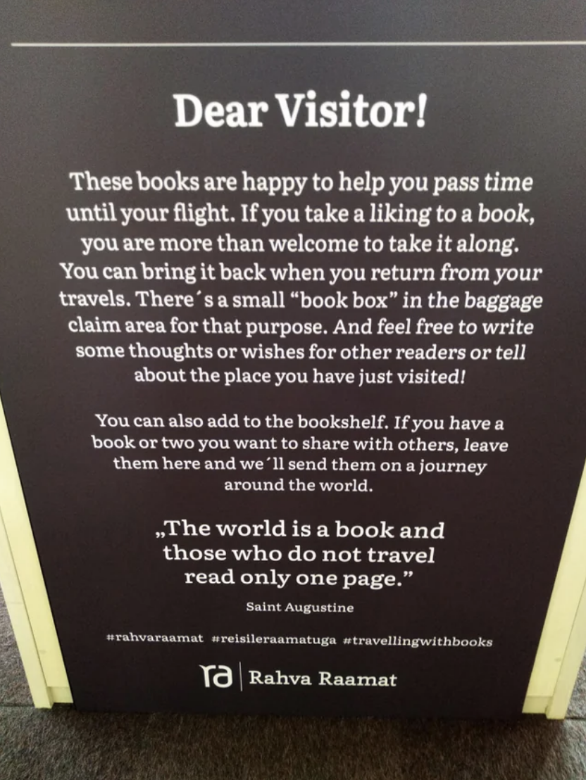 Sign at an airport inviting travelers to take a book from a book exchange and the hashtags
