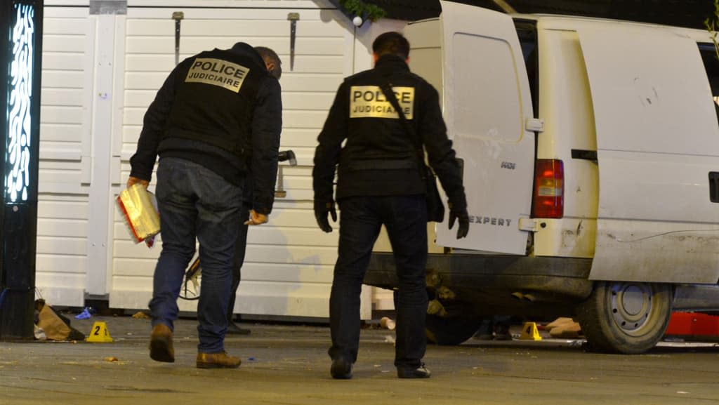 Des policiers inspectent la camionnette blanche qui s'est encastrée dans un chalet du marché de Noël, place Royale à Nantes. - Georges Gobet - AFP