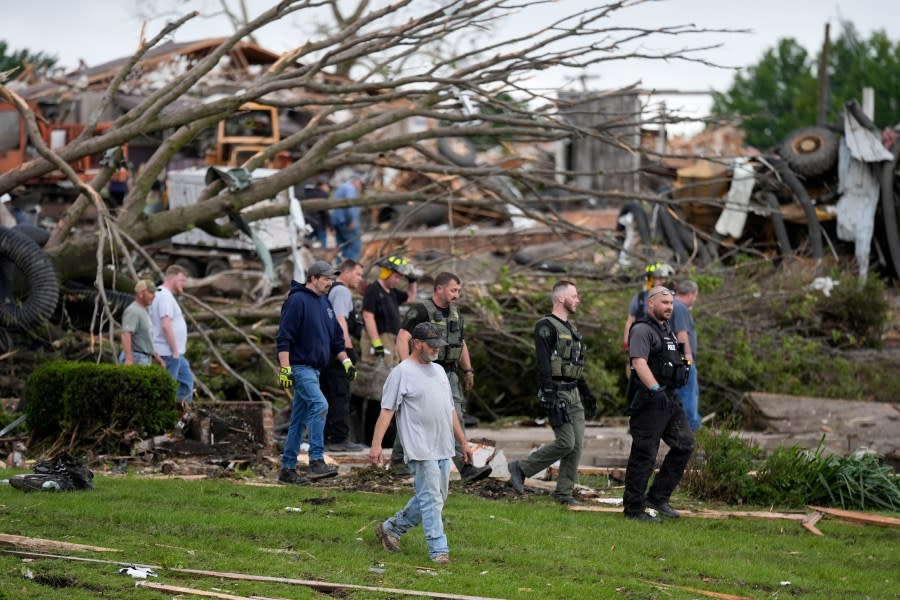 Workers search through the remains of tornado-damaged property, Tuesday, May 21, 2024, in Greenfield, Iowa. (AP Photo/Charlie Neibergall)