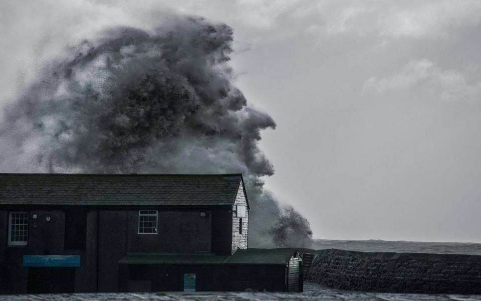 A wave lashes The Cobb harbour in Lyme Regis, Dorset, creating the illusion of a witch's face - Simon Emmett/SWNS