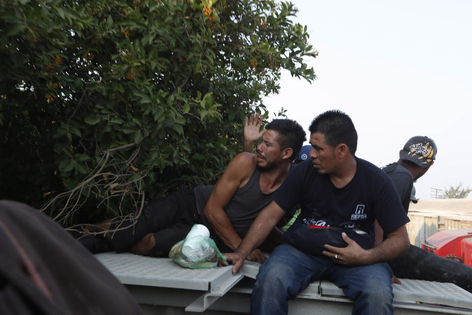 Central American migrants dodge a tree branch as they ride atop a freight train during their journey toward the US-Mexico border, in Ixtepec, Oaxaca State, Mexico, Tuesday, April 23, 2019. It's not as if the migrants think the train is safe; they acknowledge the dangers of riding through the darkness perched high atop the freight cars. (AP Photo/Moises Castillo)