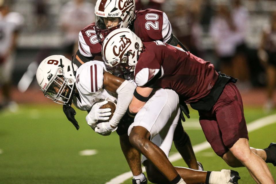 Flour Bluff's Cameran Dickson is tackled by Calallen's Elias Timbs (7) and Jude Hernandez (20) during the game at Phil Danaher Stadium on Friday, Sept. 8, 2023, in Corpus Christi, Texas.