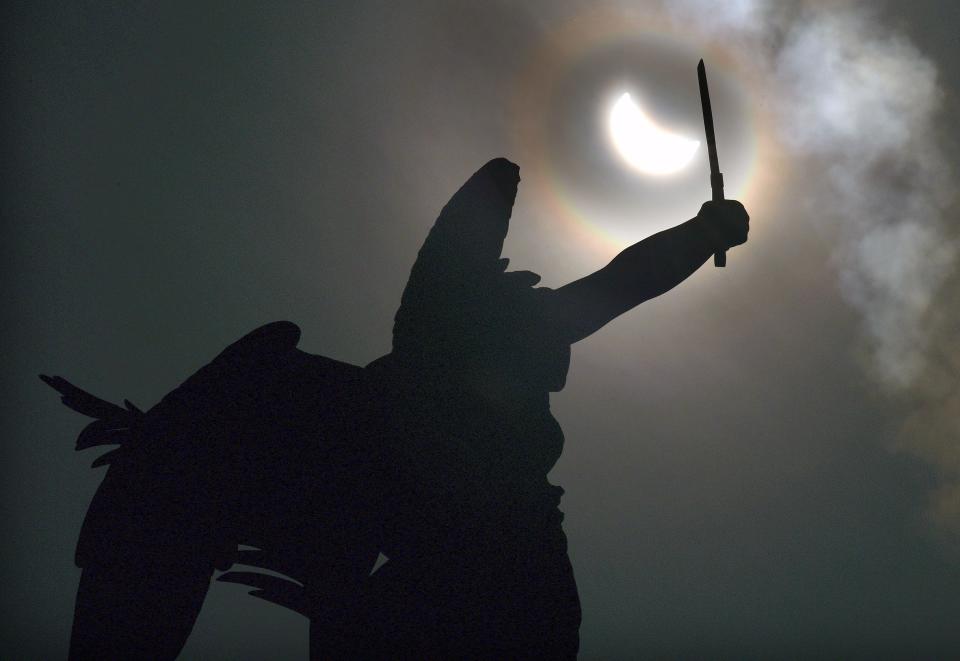 WORCESTER - The angel at the top of the Civil War monument on Worcester Common raises her sword to the partial eclipse.