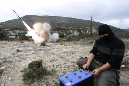 A rebel fighter fires a Grad long distance shell towards forces loyal to Syria's president Bashar Al-Assad located in the city of Jableh at the Syrian coast, from Jabal al-Akrad area in Syria's northwestern Latakia province December 4, 2014. REUTERS/Alaa Khweled