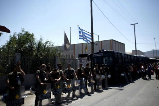 Riot police officers stand guard near the Aspropyrgou factory in Athens on July 20, 2012. Following instructions from the prosecutor and police, the steel factory in Aspropyrgos, a suburb of Athens, reopened today at dawn, after being closed for nine months due to a strike