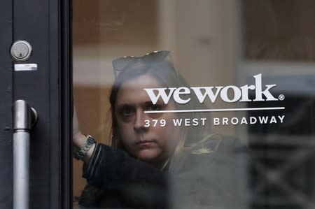 FILE PHOTO: A woman exits a WeWork co-working space in New York