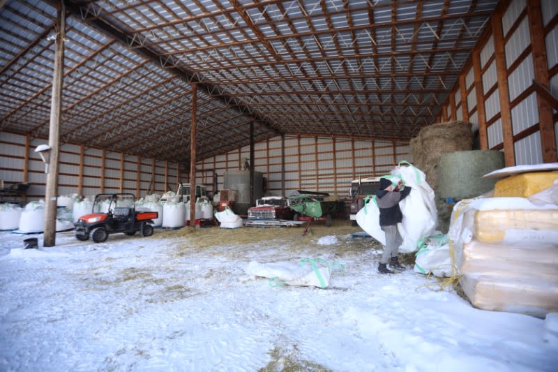 Yukon Grain Farm employee grabs a bag for feed while working at the Yukon Grain Farm near Whitehorse