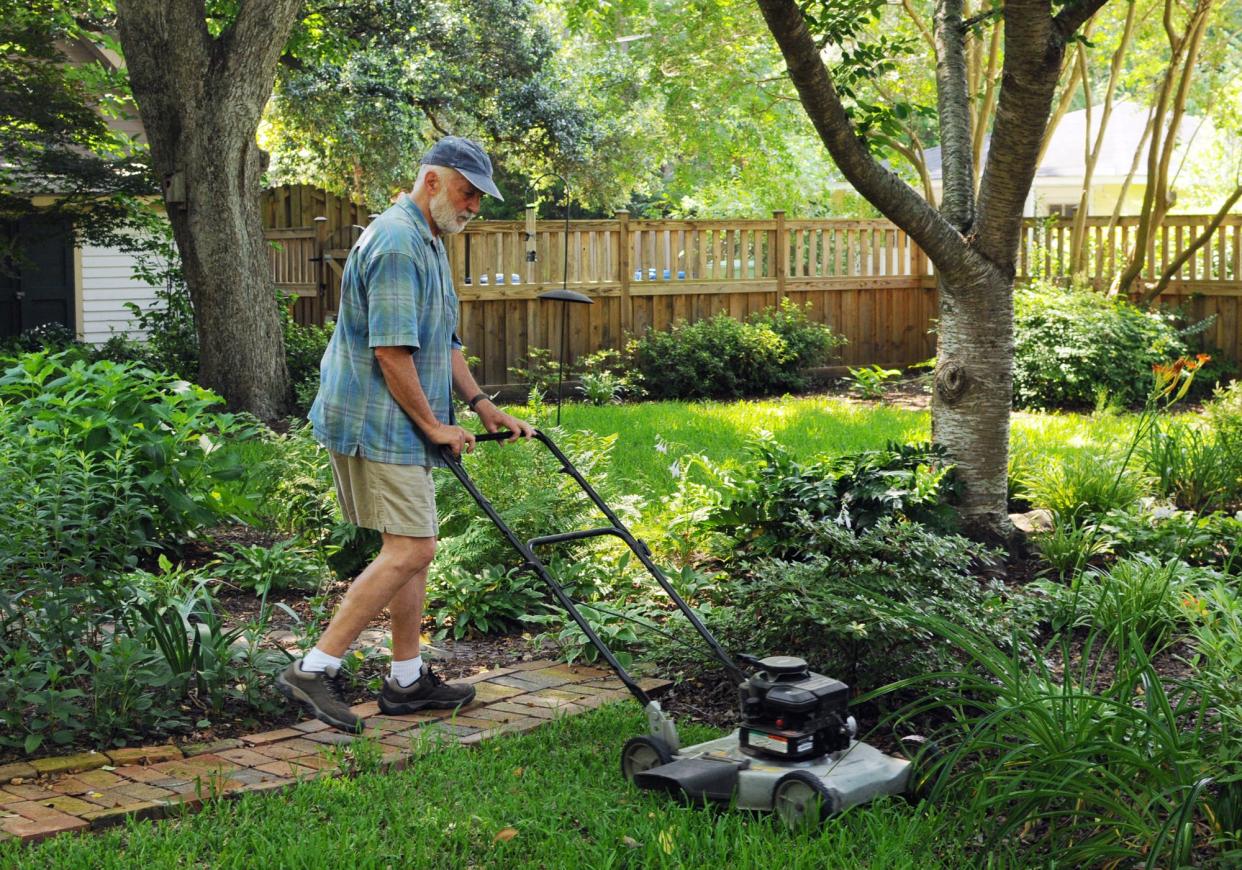 In this photo form June 22, 2015, Bill Farris, former Wilmington city manager, mows the lawn at his home on Grace Street in the Carolina Heights neighborhood in Wilmington, N.C.