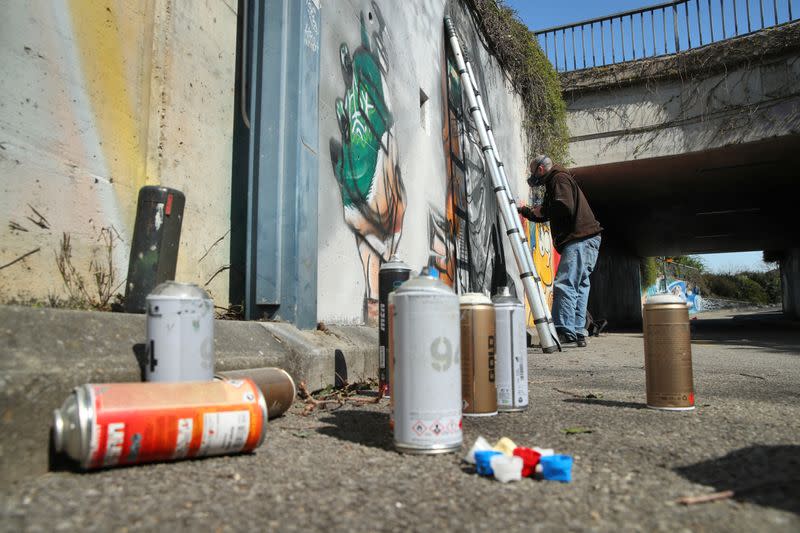 Artist Perez paints a graffiti of a cashier to pay tribute to essential workers in Gland