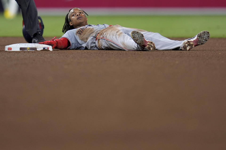 Washington Nationals' CJ Abrams keeps a hand on base after stealing second base during the seventh inning of a baseball game against the San Diego Padres, Monday, June 24, 2024, in San Diego. (AP Photo/Gregory Bull)