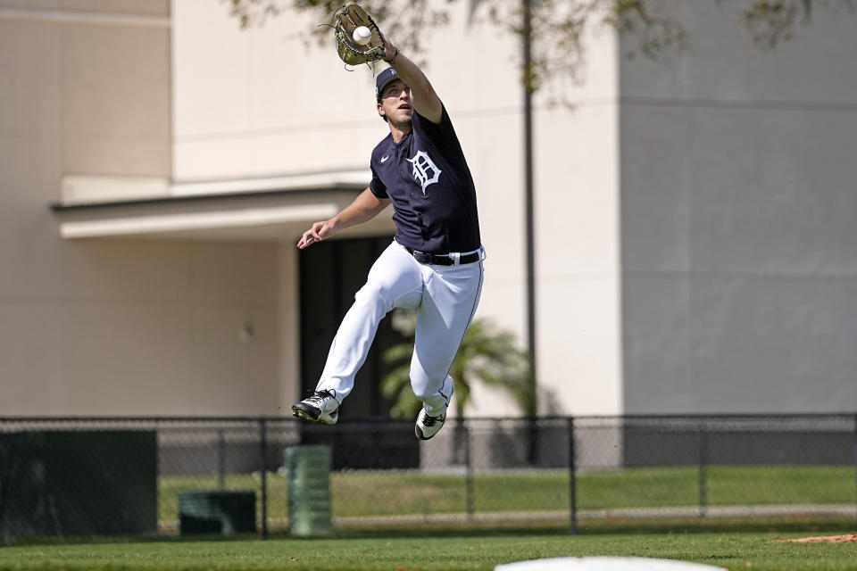 Detroit Tigers pitcher Beau Brieske leaps to catch a ball during a spring training baseball workout Wednesday, Feb. 15, 2023, in Lakeland, Fla. (AP Photo/David J. Phillip)